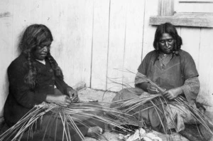 Photograph of two women weaving flax