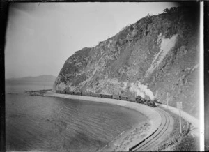 View of the Napier Mail train travelling north around Rocky Point, between Wellington and Petone, Wb & S class locomotives.