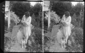 Lydia Williams feeding a Magpie, with her dog by her feet, Dunedin