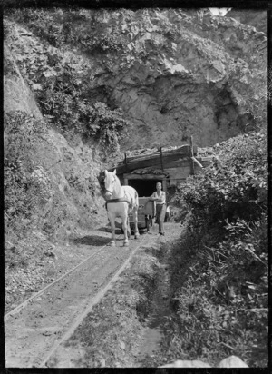 Pit pony pulling a wagon from a coal mine.