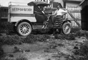 Car advertising the Golden Bay Butchery, with butcher, children and dog