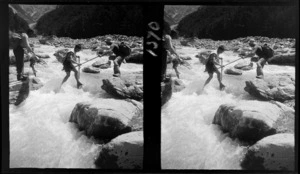 [Darran Mountains?], three unidentified men using their ice axes to cross a fast flowing mountain stream, Fiordland National Park, Southland Region