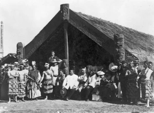 Maori group alongside a meeting house at the New Zealand International Exhibition, Christchurch, 1906-1907