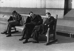 Three men resting on a bench in Trafalgar Square, London