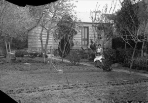 Lydia Williams, with her dog, in the garden of her cottage at Carlyle Street, Napier
