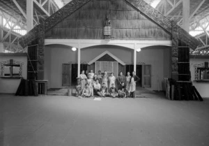 Group, including carvers and builders, alongside the unfinished meeting house in the Maori Court of the New Zealand Centennial Exhibition