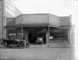 Exterior view of Lee Bros motor garage in Wanganui, with cars alongside