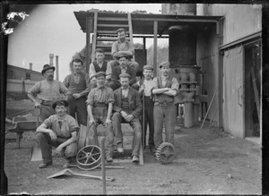 Petone Railway Workshops. Moulding staff outside the foundry with various tools and equipment visible (including a cog, spades, wheelbarrow, and wheel) at the Petone Railway Workshops, ca 1903.