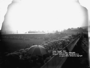Crowd of rugby spectators in the rain at Athletic Park, Wellington