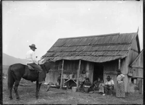 Maori group alongside a dwelling at Ohura