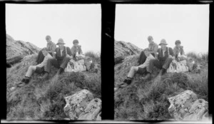 Possibly members of Williams family with dog and day packs sitting on a hill, location unknown