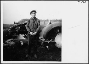 Man alongside the wreckage of an aeroplane shot down by Edgar James Kain in France during World War 2