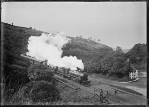 Train with two "Ab" class steam locomotives rounding a bend in the Dunedin area