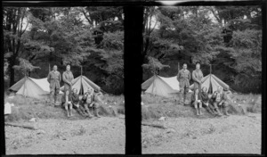 Edgar Williams standing on right with unidentified group, in front of two pitched tents, location unknown