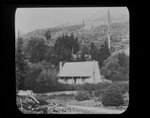 Woman standing outside of house, unidentified location