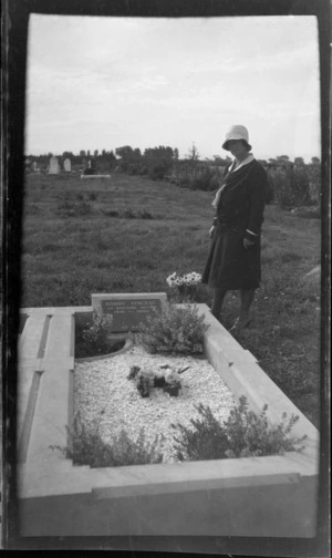 View of an unidentified woman standing by the grave of Harry Vincent of Bideford, Devon 1881-1930 at Waimairi cemetery, Burnside, Christchurch
