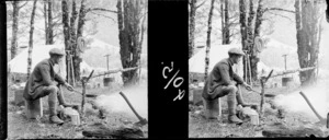 Unidentified man, cooking on a camp fire, location unidentified