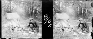 Unidentified man, by a camp fire, including a pitched tent, location unidentified