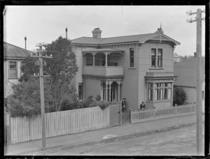 [Emily Malcolm?] in front of her two story wooden house in [Murphy Street?] with Lydia Williams, Thorndon, Wellington City