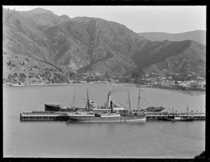 Picton with a view of the wharf, berthed ships, township, and forest covered hills