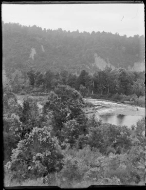 View of the [Whakapapa or Whanganui River?] surrounded by bush and forest covered hill, Kakahi Settlement, Manawatu-Whanganui Region