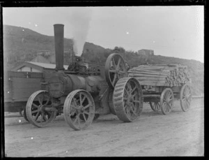 Unidentified man driving a steam tractor pulling a wagon of fence posts, Kakahi Settlement sawmill, Manawatu-Whanganui Region