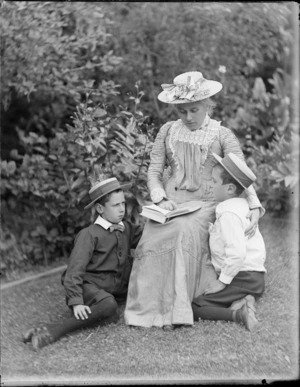 An unidentified woman [Lydia Williams' sister?], reading to Edgar and Owen Williams, in a garden, Dunedin