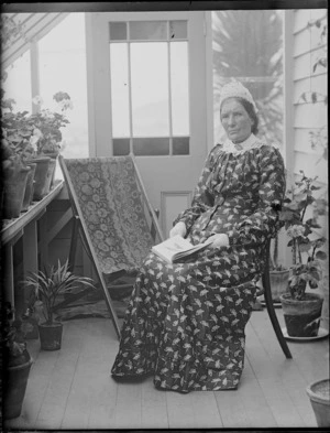 Ellen Devereux sitting in conservatory at house of William and Lydia Williams, Royal Terrace, Kew, Dunedin