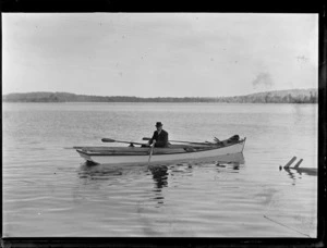 An unidentified man in a punt on harbour, location unidentified