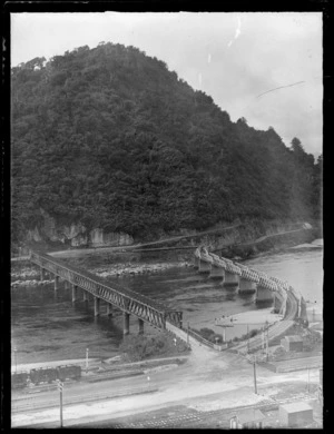 The Grey River with road and rail bridges by the town of Greymouth with a forest covered hill beyond, West Coast Region