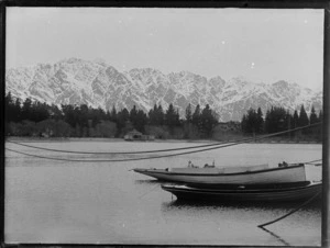 Lake Wakatipu with row boats and Queenstown Peninsula Gardens with The Bathhouse to the snow covered Remarkable Mountain Range beyond, Queenstown, Central Otago Region