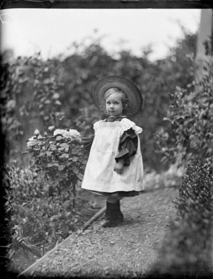 Portrait of a young Edgar Williams standing by a rose bush in the garden of the family home, at 'View Bank', Maitland Street, Dunedin