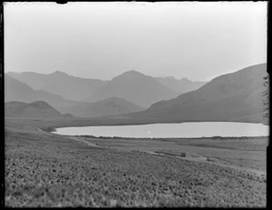 Lake Sarah and the Craigieburn Road surrounded by tussock looking to [Mount Wilson?], Selwyn District, Canterbury Region
