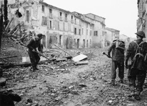 Kaye, George, b 1914 (Photographer) : World War 2 New Zealand soldiers sweep for mines on a street in Faenza, Italy