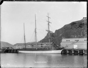 The iron barquentine 'Jerfalcon' berthed at Port Chalmers, alongside the Shaw, Savill & Albion Co. Export Stores.