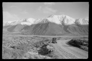 Brian Wilson Trip, a car on a shingle road with the Wilburforce River Valley and a snow covered Birdwood Mountain Range beyond, Lake Coleridge, Central Canterbury Region