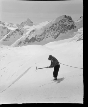 Stereographic image 2, an unidentified mountaineer cutting steps with an ice axe at the head of the Tasman Glacier with Mount Green beyond, Aoraki/Mount Cook National Park, Canterbury Region
