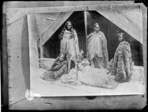Maori women next to Maori hut, at Tokaanui, Lake Taupo - Photograph taken by Burton Brothers