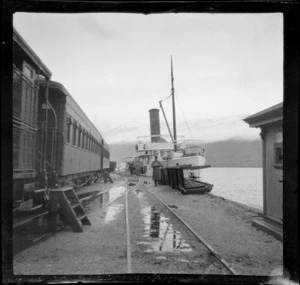 Passenger steam train on rail tracks beside Earnslaw steamship docked at wharf, Kingston, Lake Wakatipu