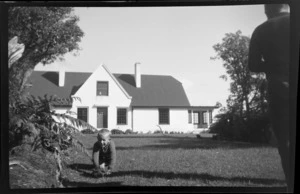 View of house at Moturau Moana with unidentified man and boy in foreground, Stewart Island/Rakiura