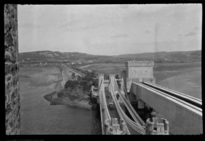 View from Conwy Castle over the Telford's turreted suspension bridge with cars next to the walkway and rail bridges over the Afon Conwy, North Wales