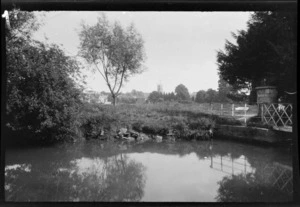 The [Oxford?] canal system with view across farmland to unidentified church bell tower and town in the distance, [Oxfordshire?], England