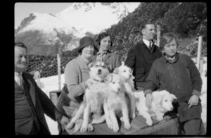 Group of people, with huskies sitting on kennel, Mount Cook area