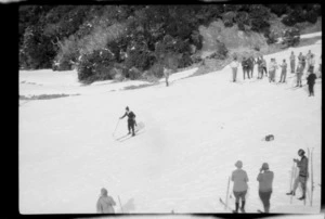 Single unidentified skier, with a large group of skiers behind, Hermitage, Mount Cook National Park, Canterbury Region