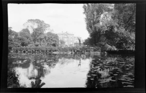 View of pond, with trees and a building in the background, Oxford, England