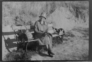 Alice Williams sitting on a park bench, with long grass in the background, probably Christchurch