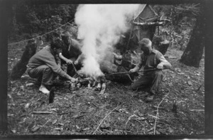 Three unidentified men, probably burning rabbit skins in a camp fire, during No.1 Wilkin's trip, West Coast Region