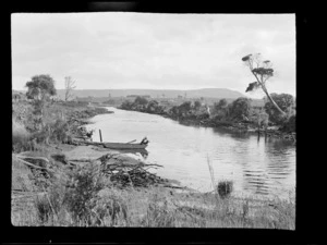 An unidentified woman in a dinghy, on a river, possibly Catlins district, Otago region