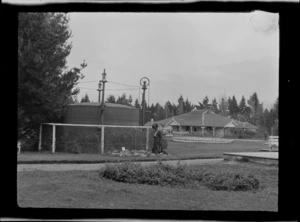 Lydia Williams beside the gasometer, with bath house and tea kiosk in background, Hanmer Springs, Canterbury Region