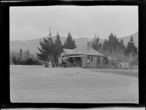 Post Office building with Lydia Williams and unidentified people standing next to passenger vehicle, Hanmer Springs, Canterbury Region